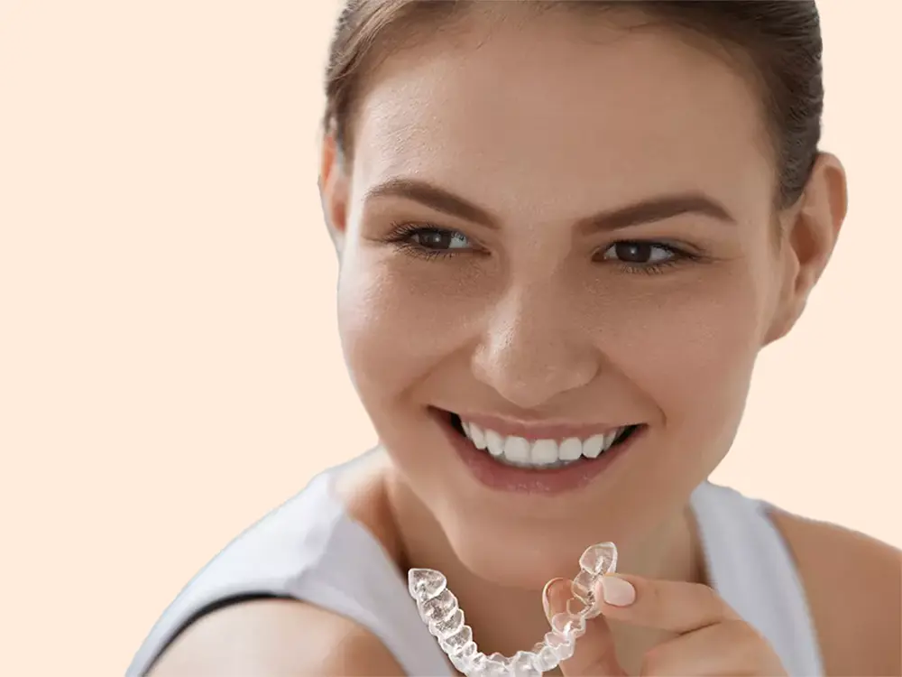 Girl Holding Invisalign Tray While Smiling